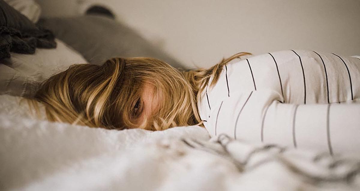 girl laying in bed with eye open