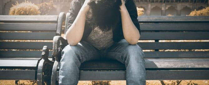 Man sitting on bench suffering depression