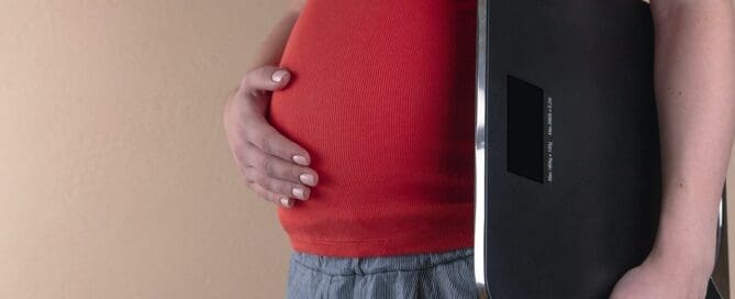 pregnant woman holding scale