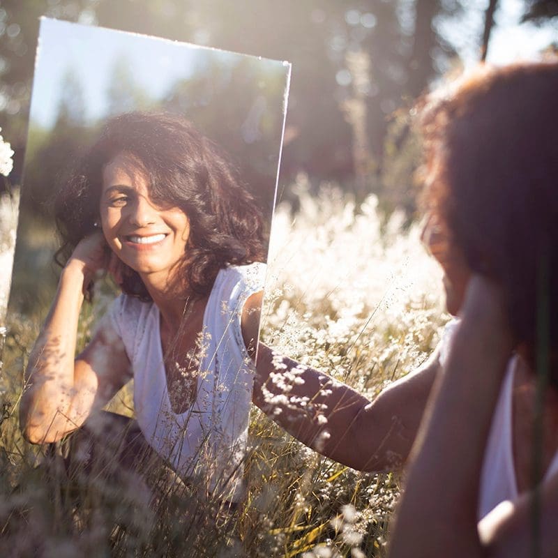 woman looking in mirror happy