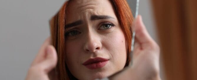 Woman looking at herself in mirror