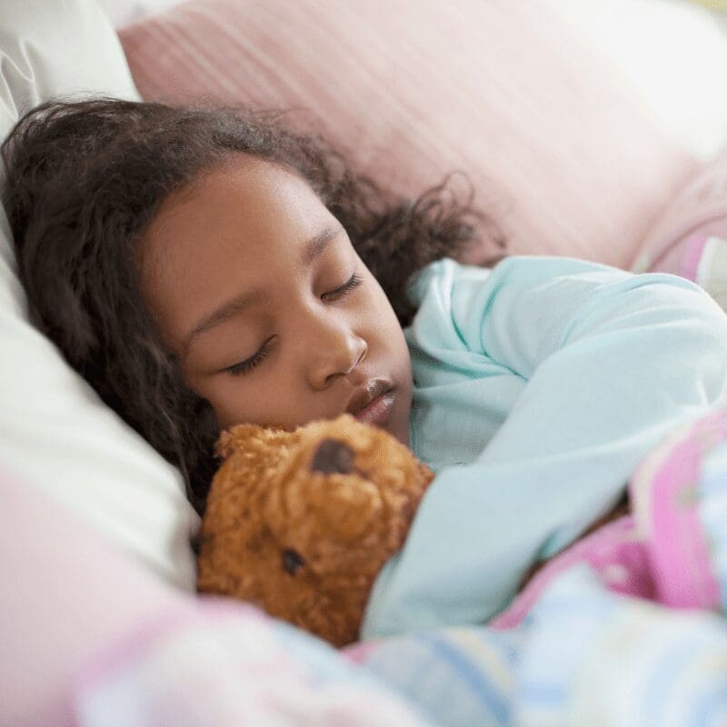 A girl sleeping with a stuffed toy A girl sleeping with a stuffed toy