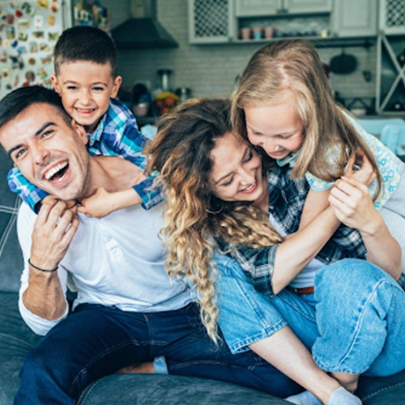 happy family laughing on the couch