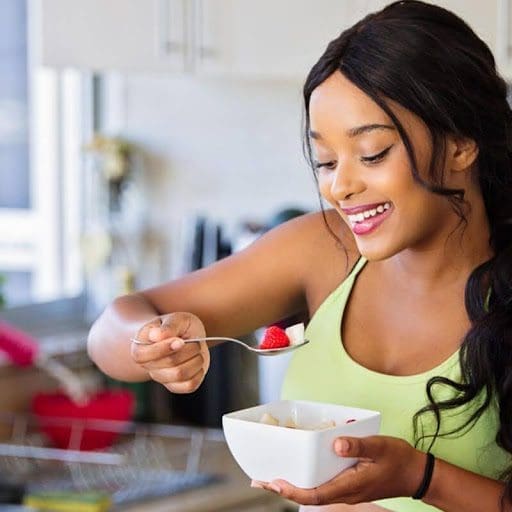 girl eating fruit in kitchen