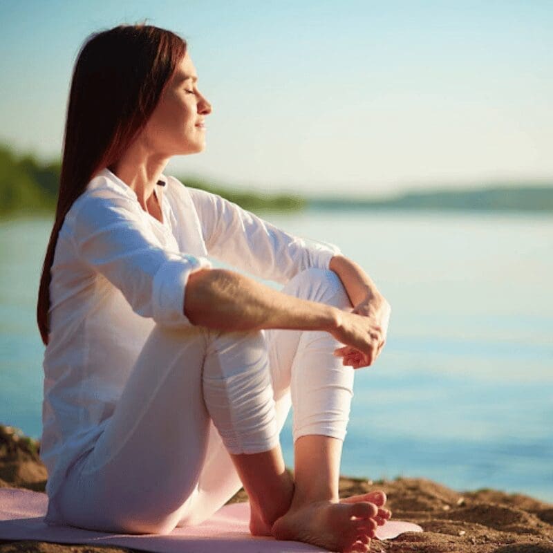 woman relaxing by the sea in sunlight