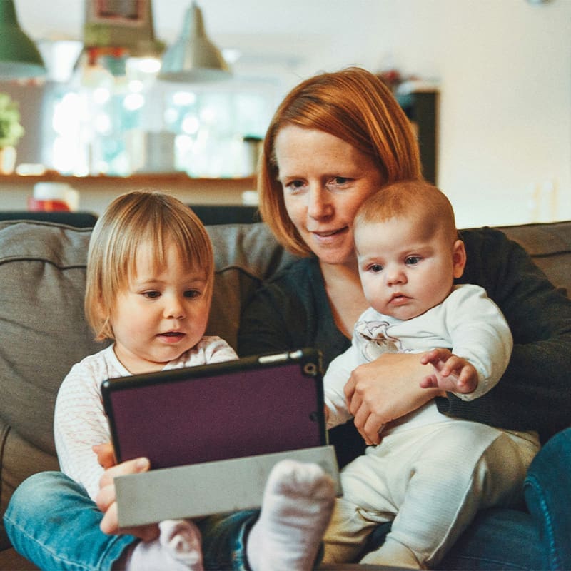 mom looking at ipad with two sons