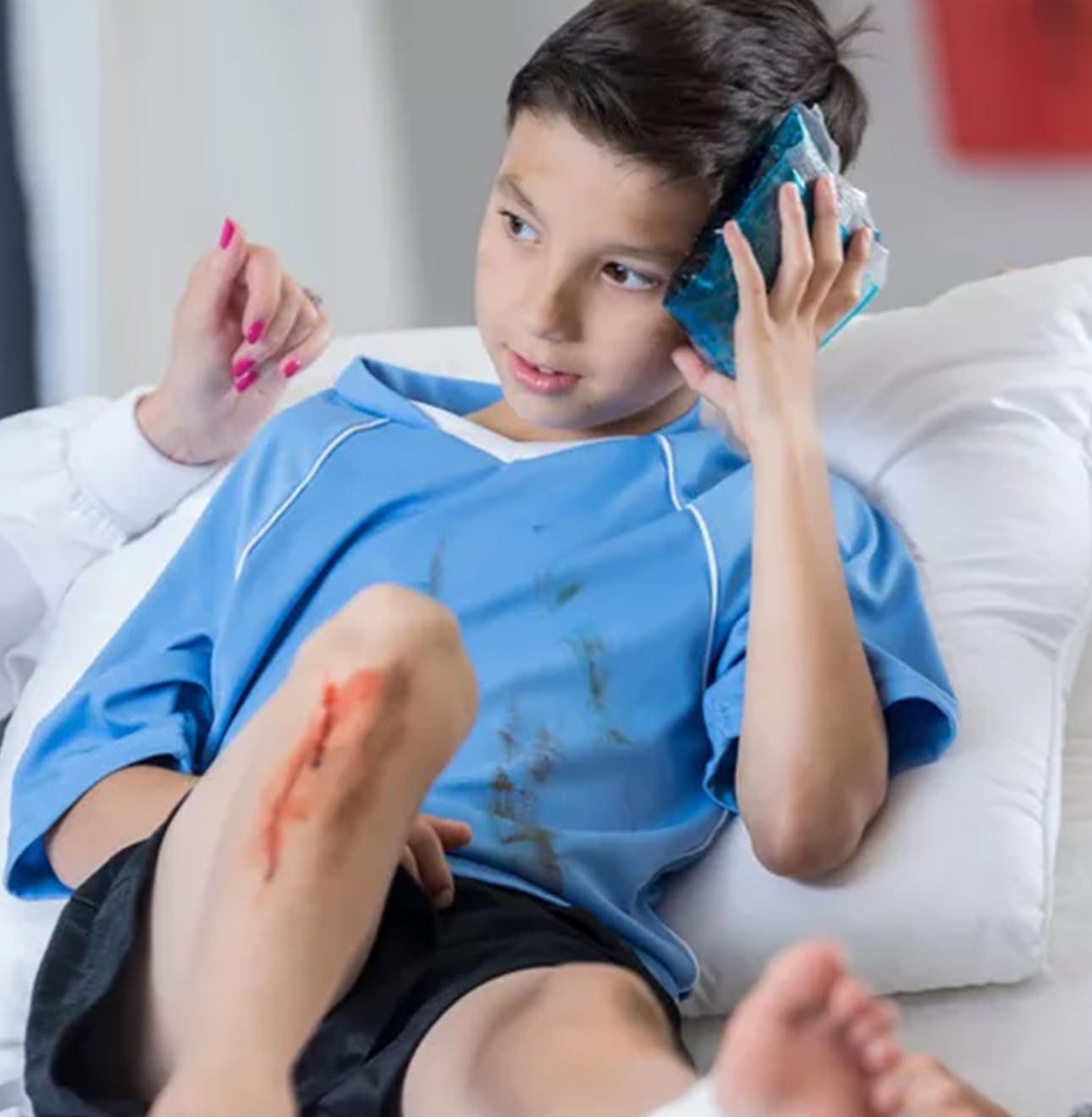 Child holding icepack on head in nurse office