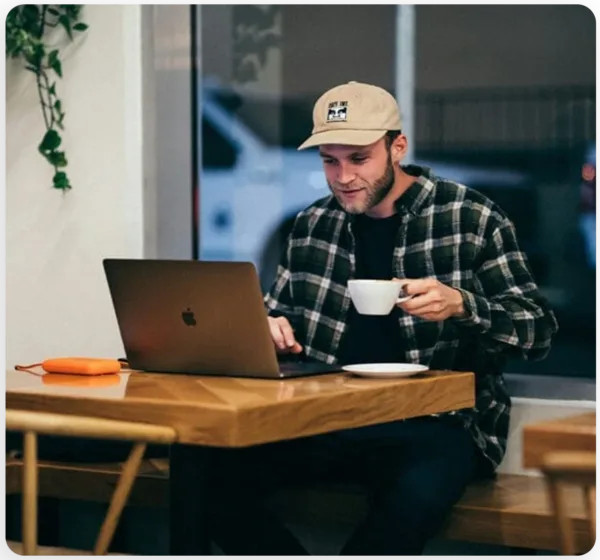 man having coffee and working with macbook