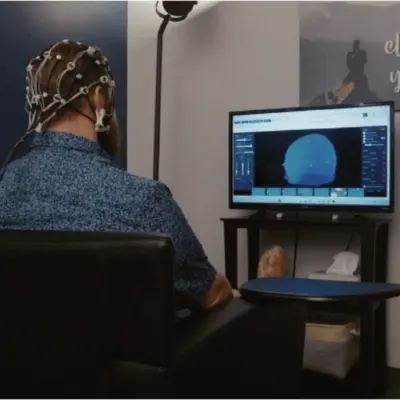 man receiving brain training wearing neurofeedback sensor cap