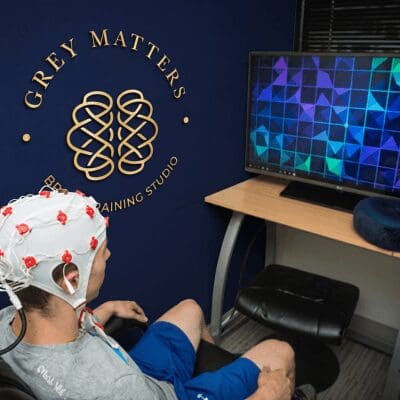 young male wearing 19 channel head cap for brain training Boy receives brain training with Grey Matters Brain Training Studio in Carmel Indiana with visual on-screen display